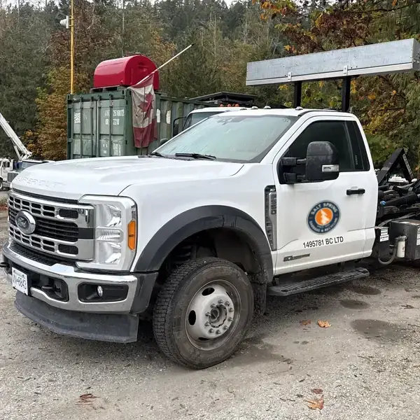 White Ford F-550 hook-lift truck that delivers Salt Spring Garbage & Recycling rental bins
