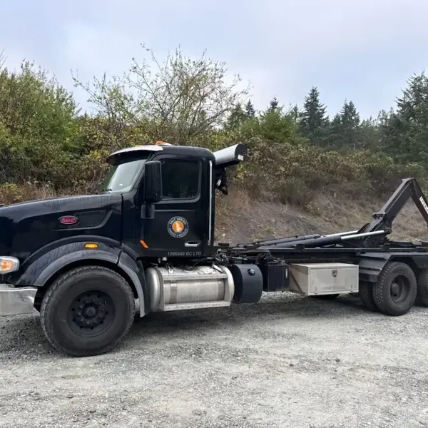 Black Salt Spring Garbage & Recycling Peterbilt hook-lift truck with the round company logo
