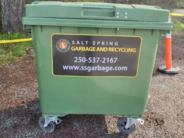 Green 1100 L wheeled commercial bin with the Salt Spring Garbage & Recycling decal