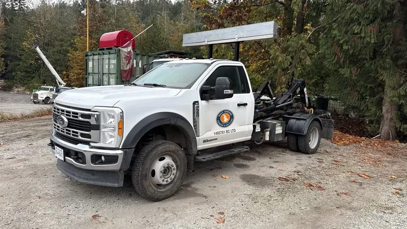 White Ford F-550 hook-lift truck from Salt Spring Garbage & Recycling, ready to deliver a rental bin